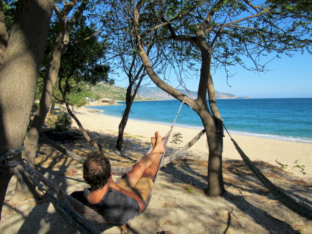 Travelers can relax on the soft sand under casuarina trees and enjoy the peaceful rhythm of the waves center